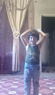 A young girl is standing up with her hands on her head
