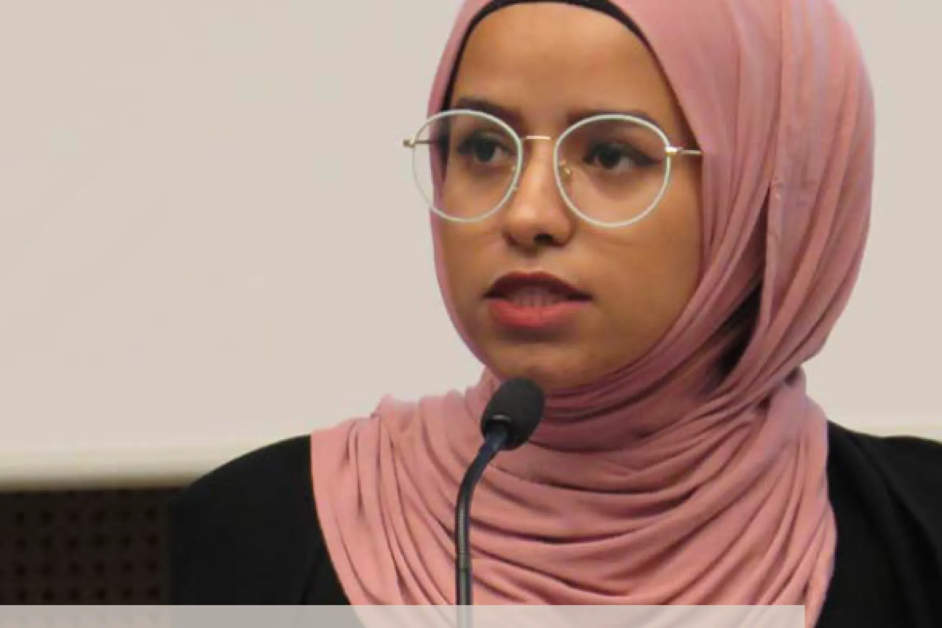 Portrait of a young woman speaking in a micro