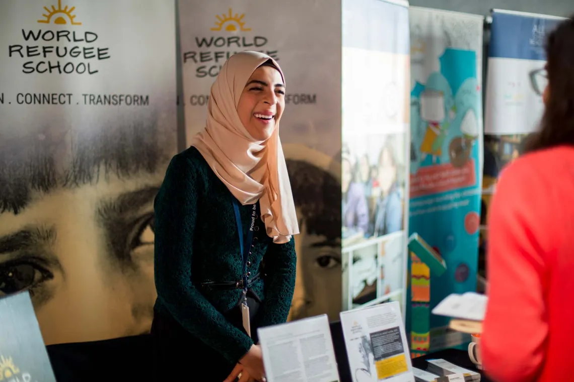 A smiling woman standing in front of her booth