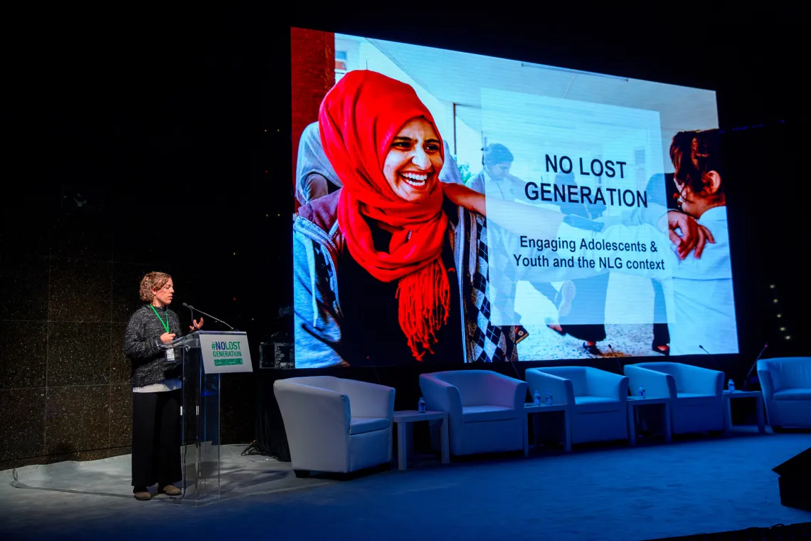 A woman is presenting a slide untitled "No Lost Generation: Engaging Adolescents & Youth and the NLG context"