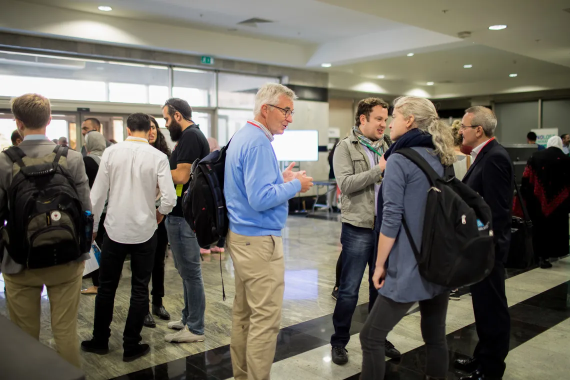 A group of people speaking in a corridor