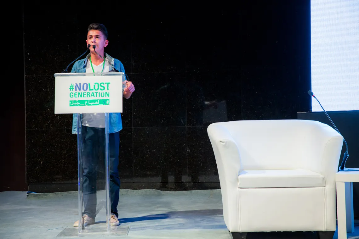 A young man is presenting on a stage