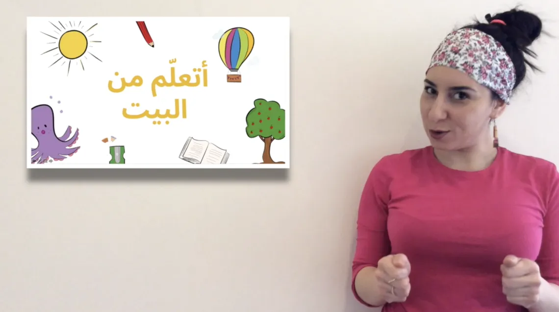 A female teacher is standing beside an online white board