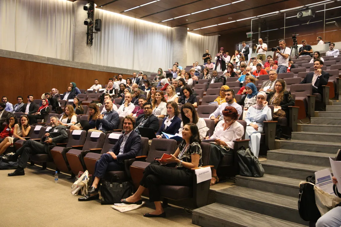 A crowd of 50 people sitting in an amphitheater