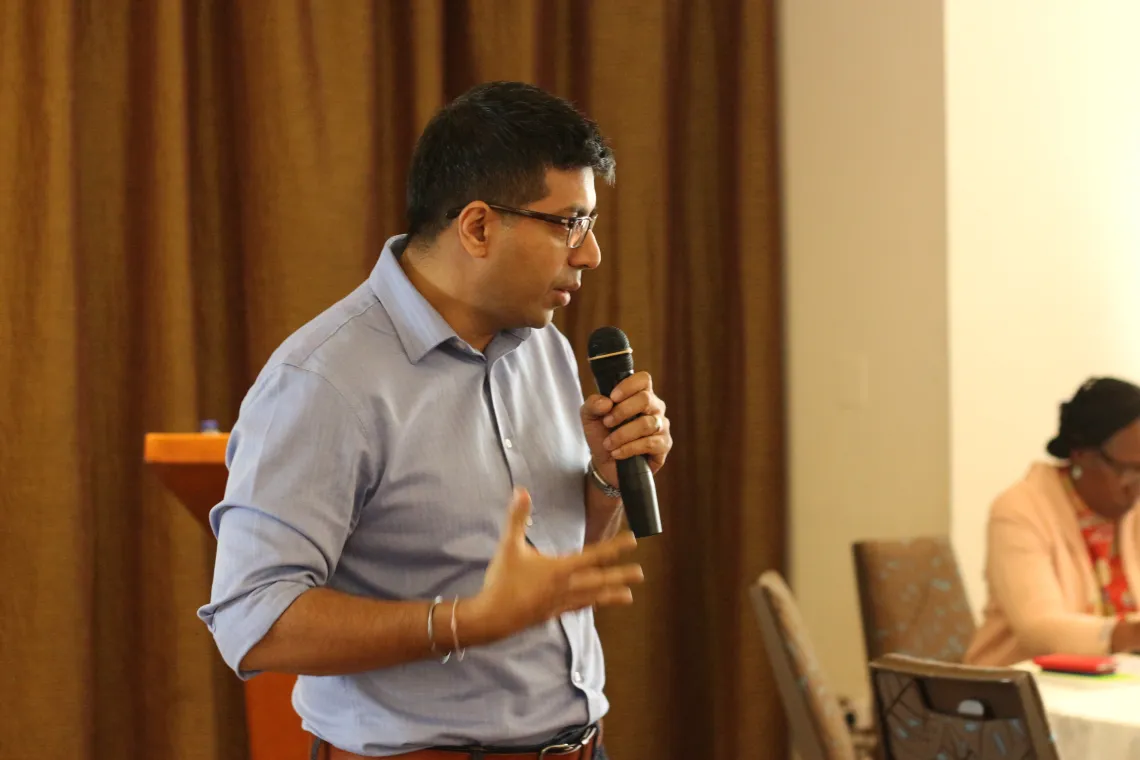 A man is standing and speaking in a micro