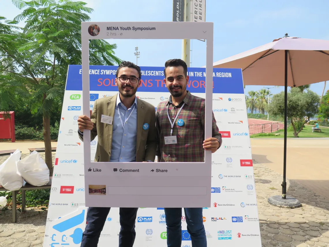 Two young men posing with a photo frame