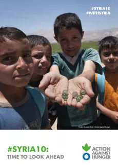 Four children are outside, one of them is showing seeds in his hands